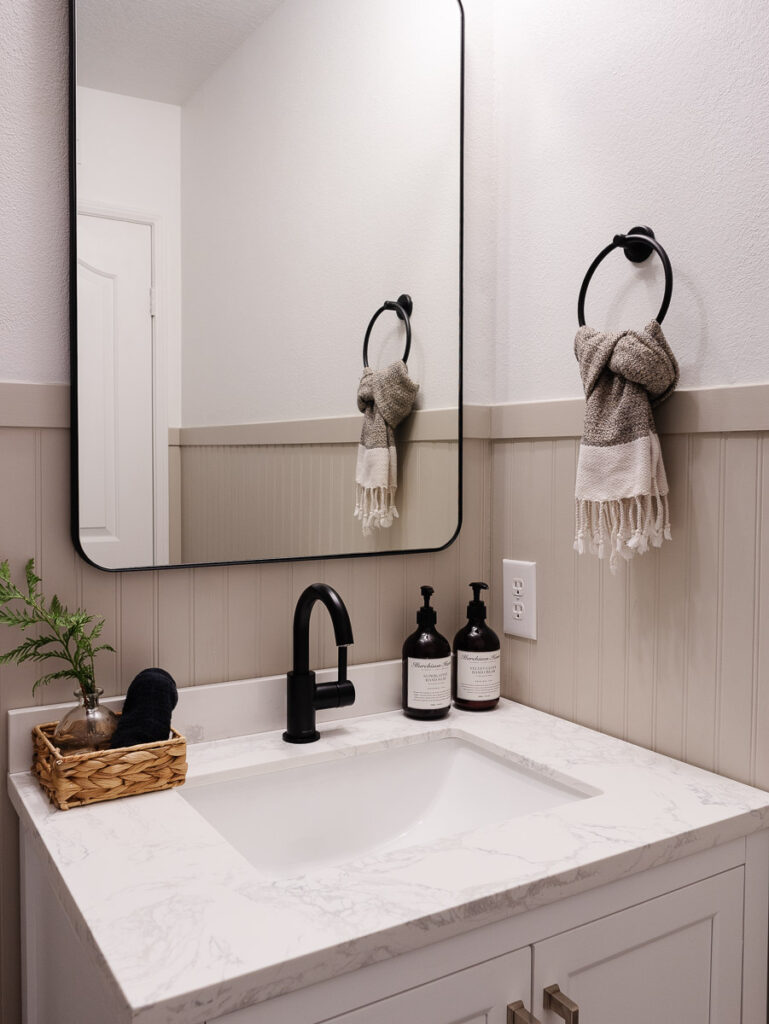 This image displays a small bathroom with headboard and black accents